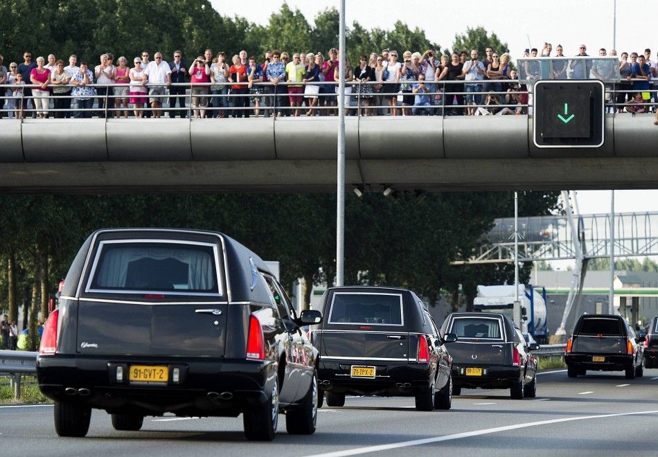 Spectators watch a convoy of hearses carrying victims of the Malaysia Airlines flight MH17 plane disaster on highway A27 near Nieuwegein on their way to be identified by forensic experts in Hilversum, July 24, 2014.      REUTERSToussaint KluitersUnited 