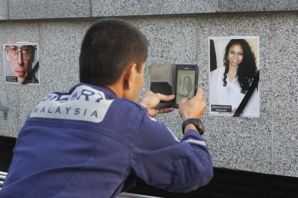 An expert of Special Malaysia Disaster Assistance and Rescue Team SMART photographs the portrait of a victim of the crashed Malaysia Airlines Flight MH17 airliner, during a memorial ceremony at Liberty Square in Kharkiv July 24, 2014. REUTERSValentyn O