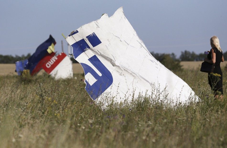 A woman takes a photograph of wreckage at the crash site of Malaysia Airlines Flight MH17 near the village of Hrabove Grabovo, Donetsk region July 26, 2014. Nearly 300 people, 193 of them Dutch citizens, were killed when the Malaysia Airlines plane en r