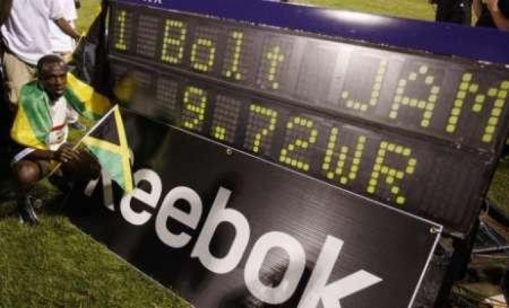 Usain Bolt of Jamaica celebrates next to the scoreboard after setting a new world record in the men's 100 meters race