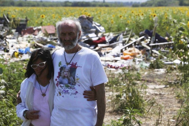 Perth parents of a victim walk near wreckage of the downed Malaysia Airlines Flight MH17 near the village of Hrabove 