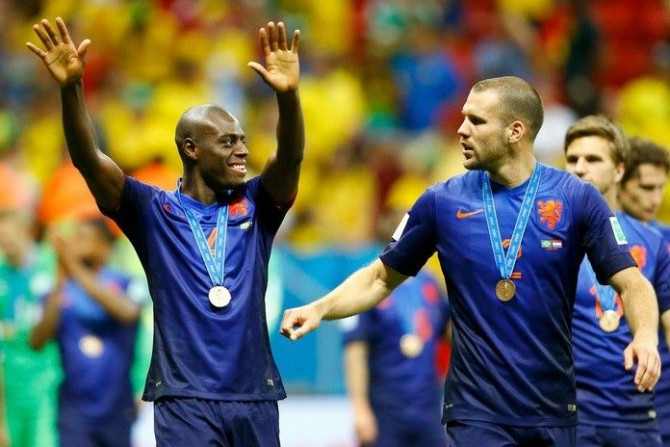 Bruno Martins Indi (L) and Ron Vlaar of the Netherlands celebrate after receiving their medals at the medal ceremony after winning their 2014 World Cup third-place playoff against Brazil at the Brasilia national stadium in Brasilia July 12, 2014.