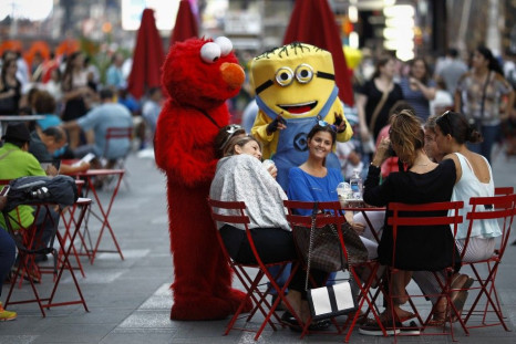 Jorge, an immigrant from Mexico, poses with women while dressed as the Sesame Street character