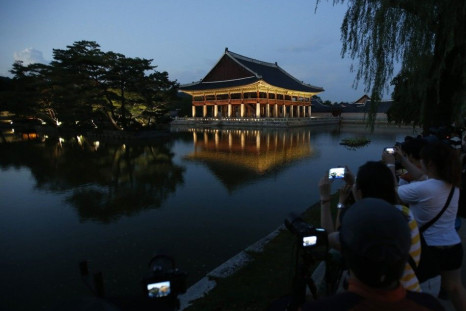 Visitors take photographs of Gyeonghoeru Pavilion, which is part of Gyeongbok Palace