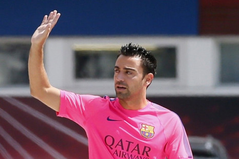 FC Barcelona's player Xavi Hernandez waves before a news conference at Joan Gamper training camp, near Barcelona August 5, 2014. Spain midfielder Xavi has retired from internationals at the age of 34, he said on Tuesday. The Barcelona player represen