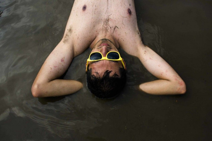 A man rests in a mud pit near the main stage at the Woodstock Festival in Kostrzyn-upon-Odra, close to the Polish-German border