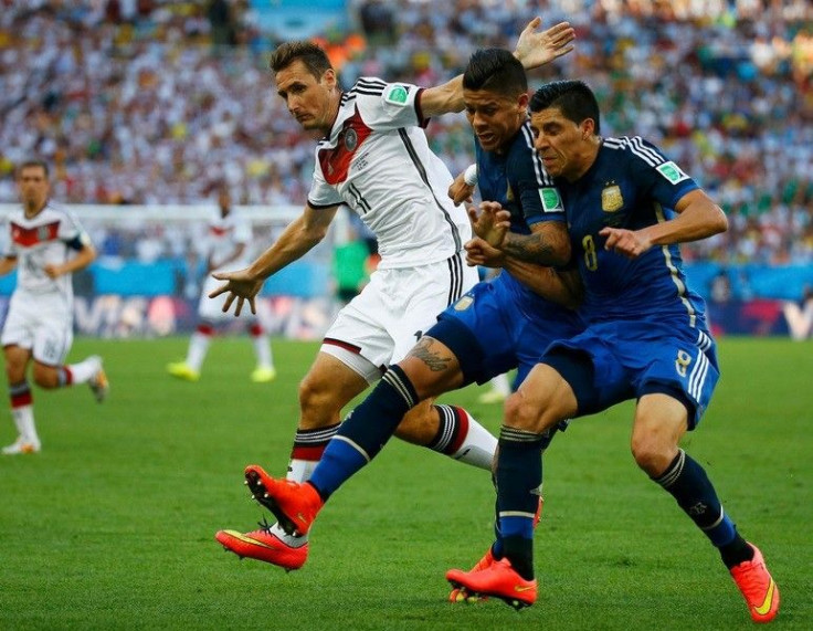 Germany's Miroslav Klose (L) runs alongside Argentina's Marcos Rojo and Enzo Perez (R) during their 2014 World Cup final at the Maracana stadium in Rio de Janeiro July 13, 2014.