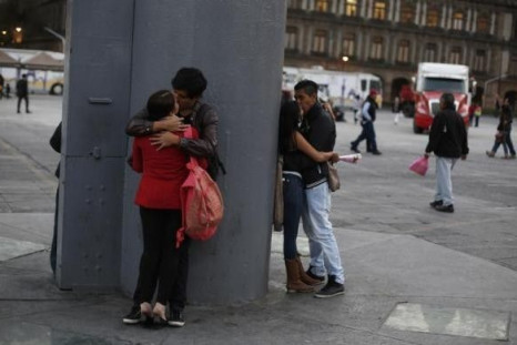 Couples kiss at the base of the flag pole at the Zocalo square in downtown Mexico City January 17, 2013.