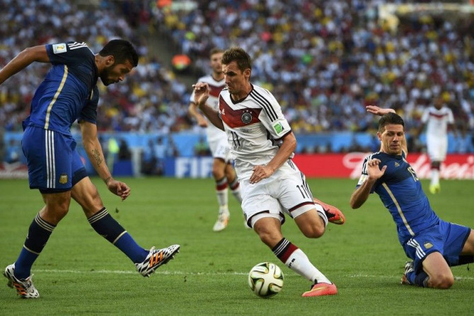 Germany&#039;s Miroslav Klose kicks the ball between Argentina&#039;s Ezequiel Garay (L) and Martin Demichelis (R)