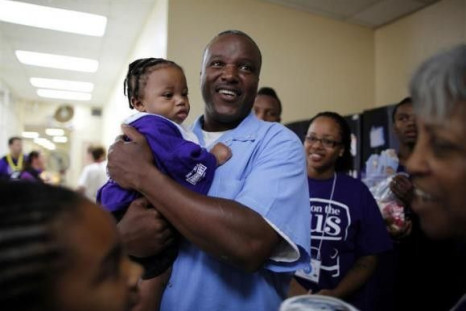 Troy, 43, (C) holds his eight-month-old grandson B.J. for the first time at San Quentin state prison for a Father&#039;s Day visit organised by &quot;Get on the Bus&quot; in San Quentin, California June 8, 2012.