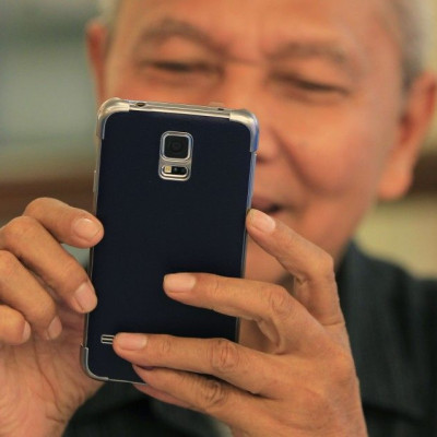 A man reacts while trying out his new Samsung Galaxy S5 in Jakarta