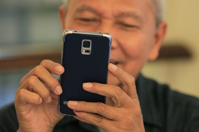 A man reacts while trying out his new Samsung Galaxy S5 in Jakarta