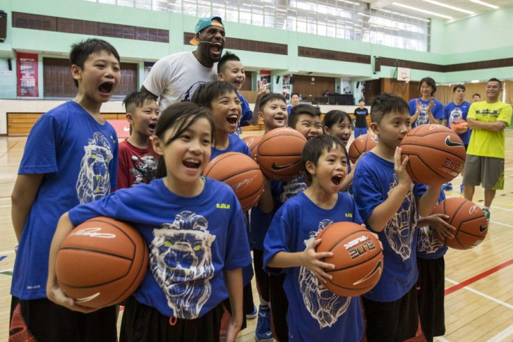 LEBRON JAMES POSES WITH CHILDREN AFTER A BASKETBALL CLINIC IN HONGKONG