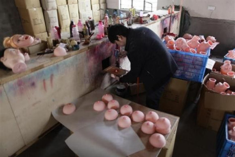 A worker sprays pink color on a nipple of an unfinished breast for an inflatable sex doll at Ningbo Yamei plastic toy factory, on the outskirts of Fenghua, Zhejiang province, February 13, 2012.