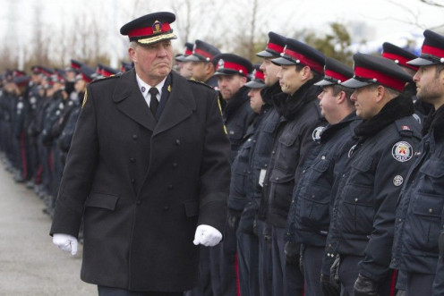 Toronto police chief Blair walks by officers lining the roadway at the public memorial for police constable John Zivcic in Toronto in this file photo