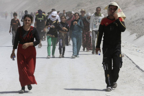 Displaced people from the minority Yazidi sect, who fled the violence in the Iraqi town of Sinjar, march in a demonstration at the Iraqi-Turkish border crossing in Zakho district