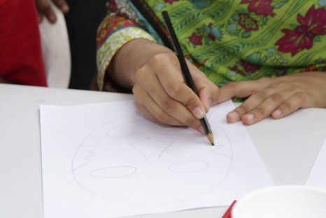 Pakistani schoolgirl activist Malala Yousafzai draws a face
