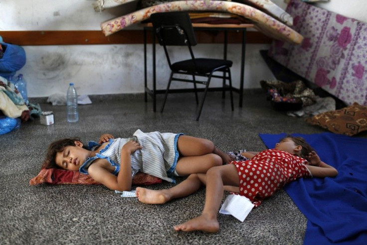 Girls sleep on the floor of a classroom in a United Nations-run school hosting internally displaced Palestinians