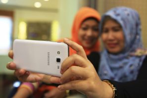 Muslim women take pictures of themselves with a Samsung Galaxy Grand