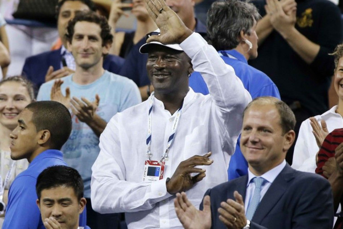 Former basketball great Michael Jordan waves to Roger Federer of Switzerland after Federer defeated Marinko Matosevic of Australia during their men&#039;s singles match at the U.S. Open tennis tournament in New York August 26, 2014. REUTERS/Shannon Staple