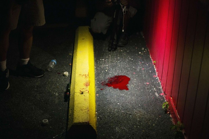 A blood pool from what witnesses said was a man who may have accidentally shot himself, is seen on the ground following a peaceful demonstration reacting to the shooting of Michael Brown in Ferguson