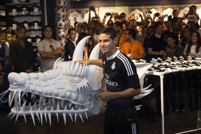 Real Madrid&#039;s James Rodriguez poses beside a model of a dragon