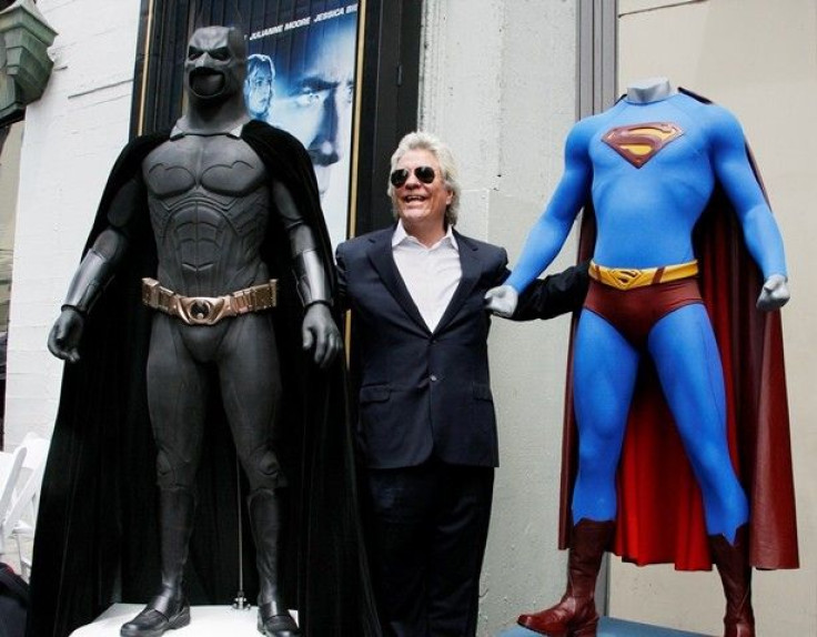 Film Producer Jon Peters Poses With A Batman, Left, And Superman, Right, Costume.