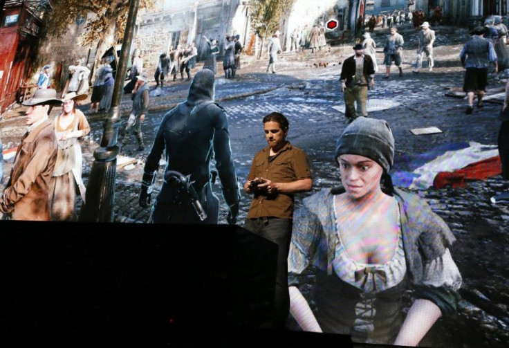 A Man Plays The Game "Assassin's Creed: Unity" On Stage.