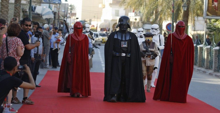 People dressed up as Darth Vader (C) and the Emperor's Royal Guard (in red) from the Star Wars movies