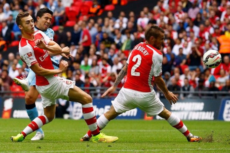 Manchester City's Samir Nasri (2nd L) shoots past Arsenal's Calum Chambers (L) and Arsenal's Mathieu Debuchy during their English Community Shield soccer match at Wembley Stadium in London, August 10, 2014.