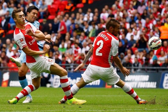 Manchester City's Samir Nasri (2nd L) shoots past Arsenal's Calum Chambers (L) and Arsenal's Mathieu Debuchy during their English Community Shield soccer match at Wembley Stadium in London, August 10, 2014.