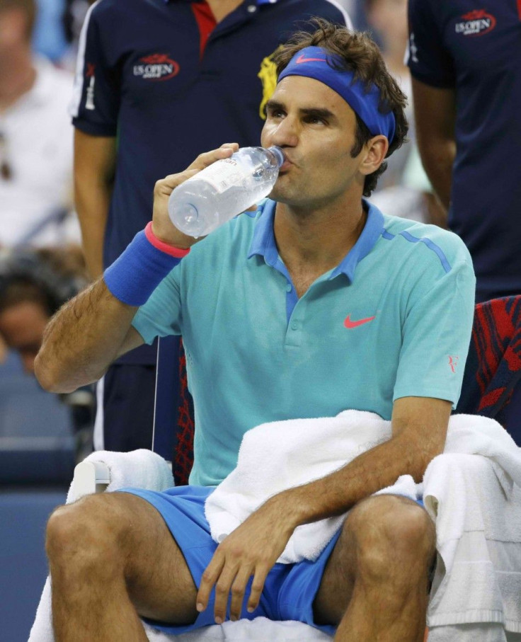 Roger Federer of Switzerland drinks before play was suspended due to rain in his match against Marcel Granollers of Spain at the 2014 U.S. Open tennis tournament in New York, August 31, 2014. REUTERS/Ray Stubblebine