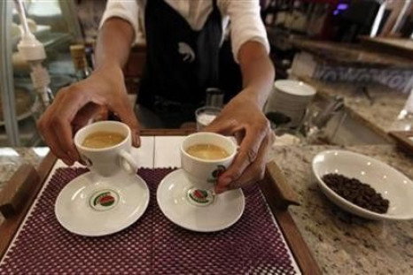 A waitress serves coffee to customers at a coffee bar in Sao Paulo
