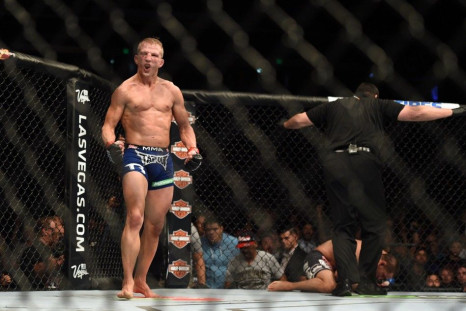 August 30, 2014; Sacramento, CA, USA; T.J. Dillashaw (red gloves) reacts after knocking down Joe Soto (blue gloves) during the bantamweight title bout of UFC 177 at Sleep Train Arena.