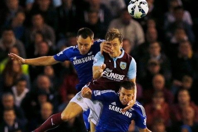 Chelsea&#039;s John Terry (L) and Cesar Azpilicueta (bottom) challenge Burnley&#039;s Ashley Barnes during their English Premier League soccer match at Turf Moor in Burnley, northern England August 18, 2014.
