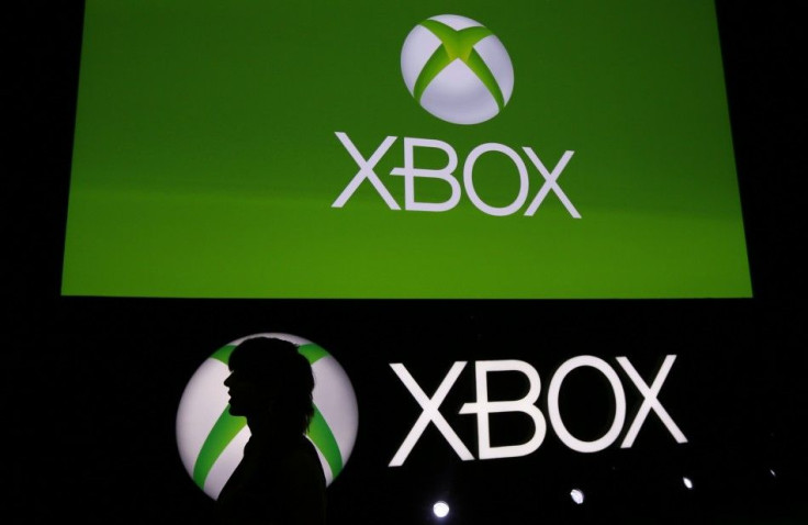 A Spanish Games blogger is silhouetted against the logo of Microsoft's Xbox during the Xbox Play Day 2014, before the Gamescom 2014 fair in Cologne August 12, 2014.
