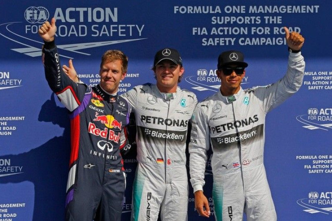 Mercedes Formula One driver Nico Rosberg of Germany (C) celebrates his pole position with team-mate Lewis Hamilton (R) of Britain, who finished second and Red Bull Racing Formula One driver Sebastian Vettel (L) of Germany, who took the third place, after 