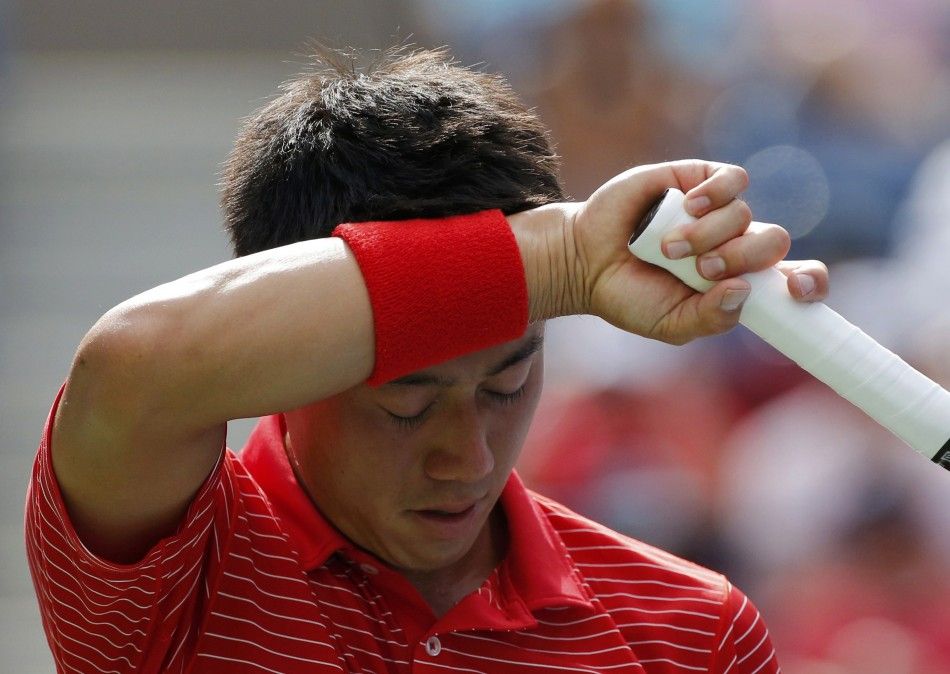 Kei Nishikori of Japan wipes his face while playing Stan Wawrinka of Switzerland