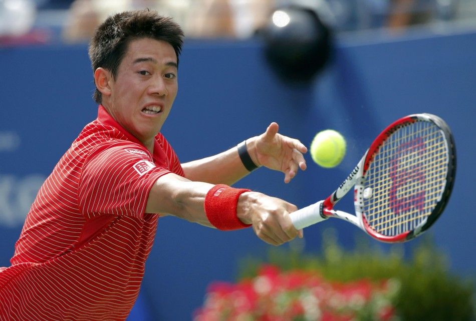 Kei Nishikori of Japan hits a return to Stan Wawrinka of Switzerland