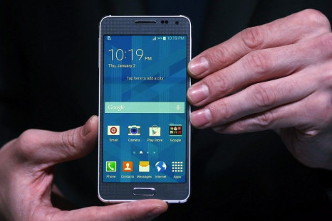 A model holds a Samsung Galaxy Alpha smartphone