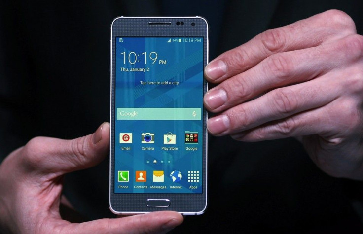 A model holds a Samsung Galaxy Alpha smartphone