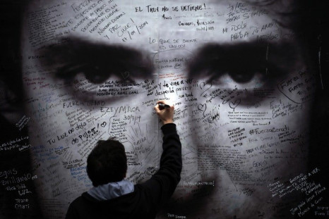 A Man Writes Over A Picture Of Argentine Musician Gustavo Cerati Placed In Front Of The Clinic Where Cerati Died Today At The Age Of 55 In Buenos Aires September 4, 2014. 