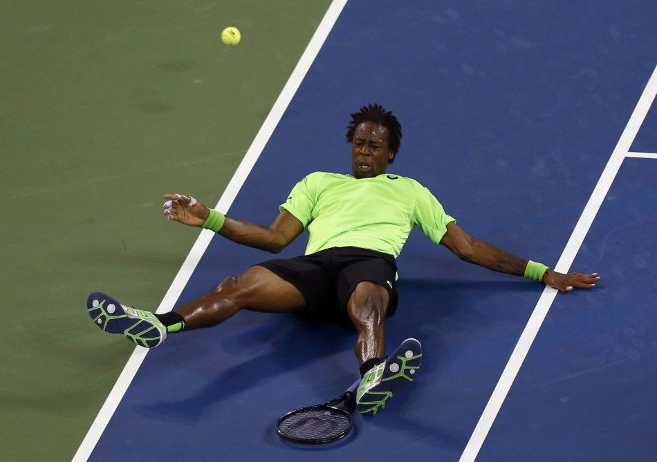 Gael Monfils of France falls to the court 