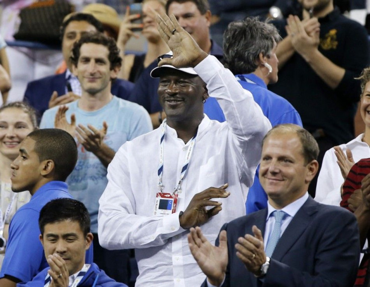 Former basketball great Michael Jordan waves to Roger Federer of Switzerland after Federer defeated Marinko Matosevic of Australia during their men&#039;s singles match at the U.S. Open tennis tournament in New York August 26, 2014.