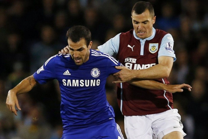 Burnley's Dean Marney challenges Chelsea's Cesc Fabregas (L) during their English Premier League soccer match at Turf Moor in Burnley, northern England August 18, 2014.