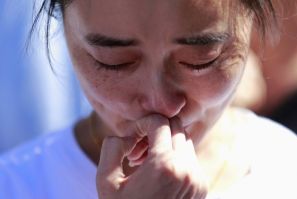 A family member of a passenger onboard the missing Malaysia Airlines Flight MH370 cries as she gathers with others to pray at Yonghegong Lama Temple in Beijing September 8, 2014, on the six-month anniversary of the disappearance of the plane.  The Boeing 