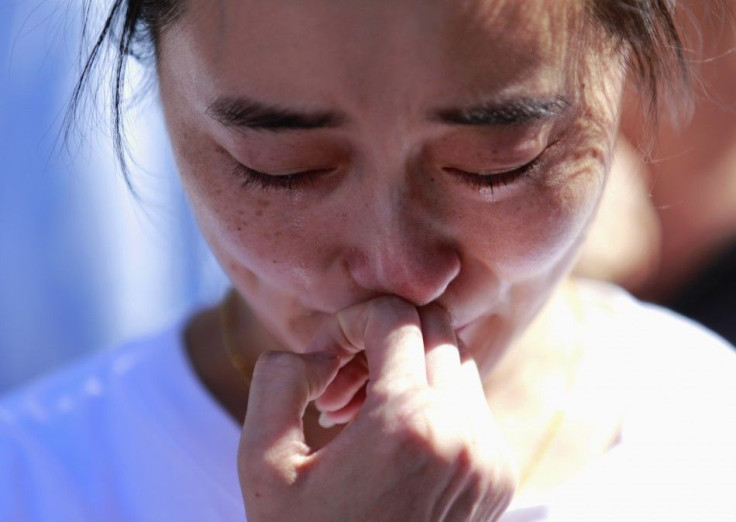 A family member of a passenger onboard the missing Malaysia Airlines Flight MH370 cries as she gathers with others to pray at Yonghegong Lama Temple in Beijing September 8, 2014, on the six-month anniversary of the disappearance of the plane.  The Boeing 