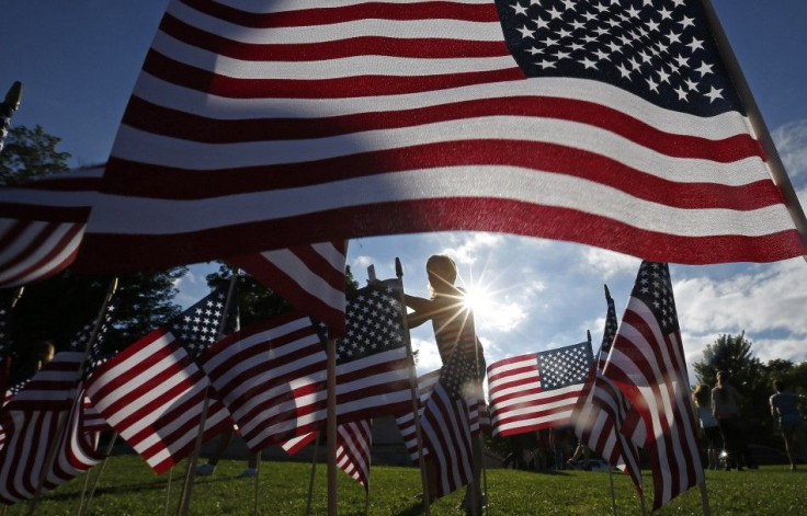 A woman stands among some of the 3,000 flags placed in memory of the lives lost in the September 11, 2001 attacks, at a park in Winnetka, Illinois September 10, 2014. On Thursday people will mark the 13th anniversary of the 9/11 attacks.