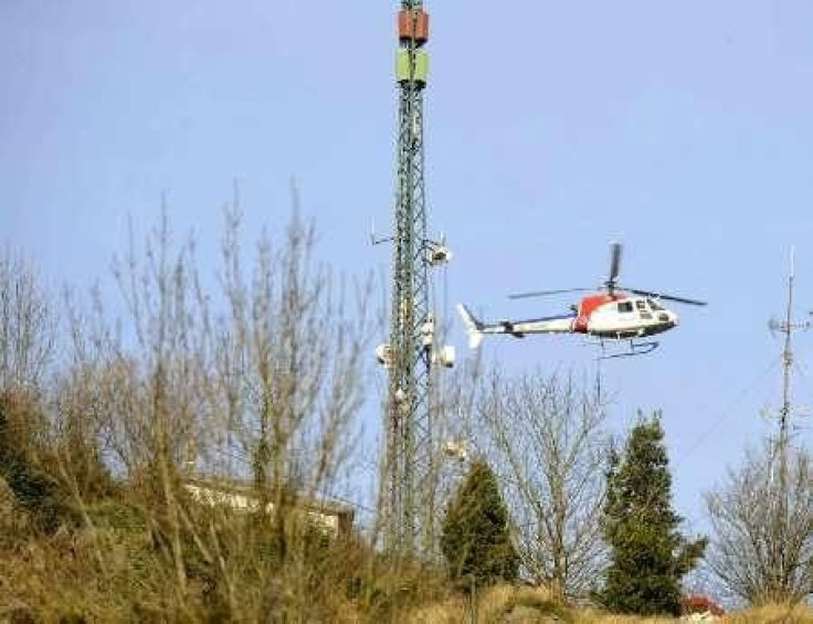 A Basque police helicopter hovers near a television and mobile phone antenna
