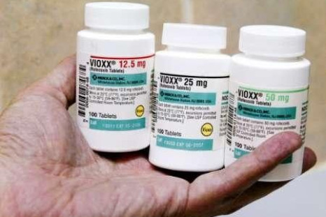 A pharmacist holds bottles of prescription arthritis and pain medication